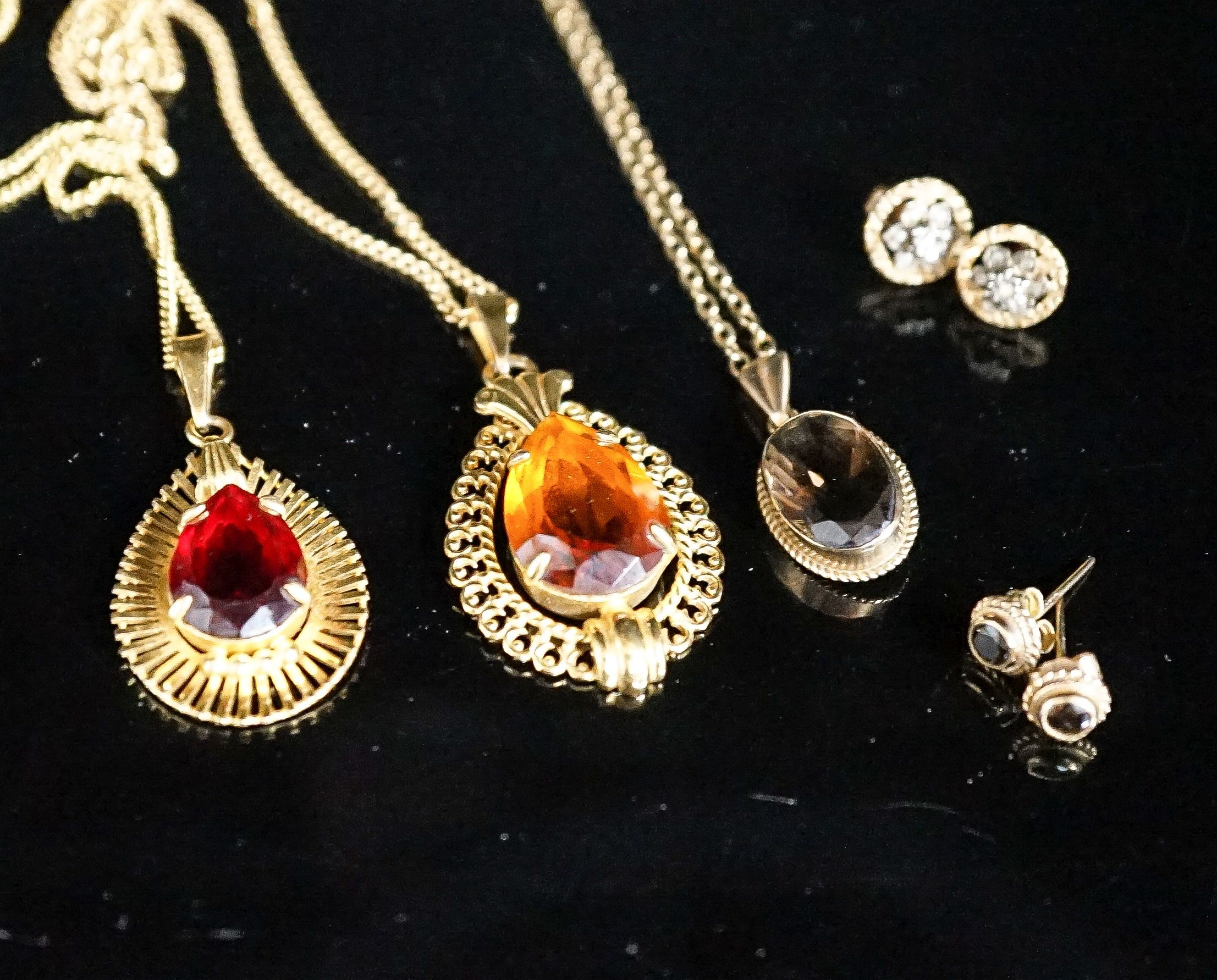 A modern 9ct gold and smoky quartz set pendant on a 9ct chain and two pairs of 9ct earrings, gross 6.2 grams and two other pendants on chains.